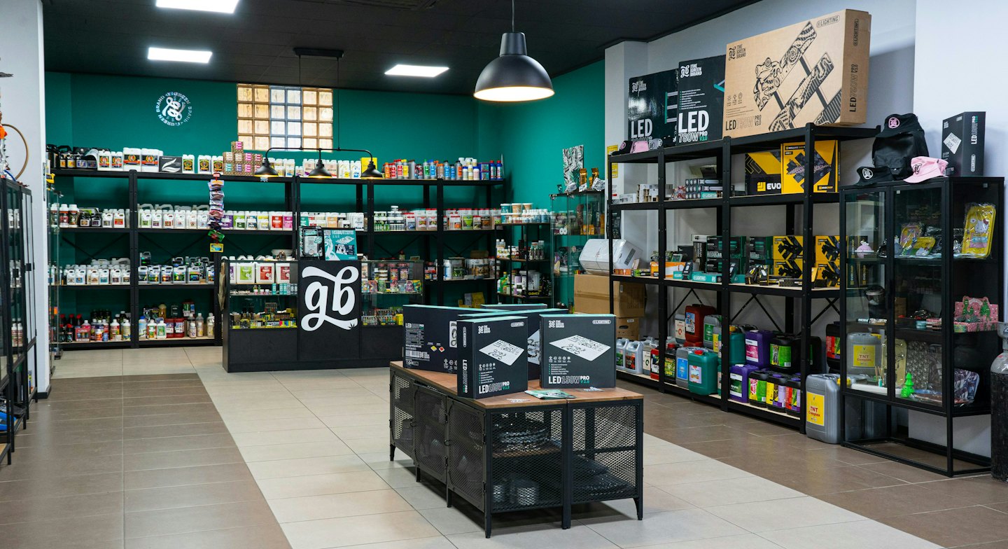 Pasillos de tienda de hidroponía llenos de suministros de jardinería y equipos de iluminación.